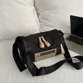 Sac bandoulière cylindrique noir sport avec étiquette beige sur lit blanc - Sans Pendentif / Noir