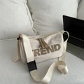 Beige nylon crossbody bag with TREND letter print on white textured sofa setting - White Without Pendant