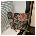 Detail der Vintage-Jacquard-Tasche mit floralem Muster und robusten braunen Ledergriffen - Schwarz