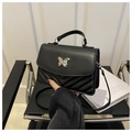 Detail of black crossbody bag featuring silver butterfly buckle and chevron stitching - Black