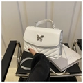Macro detail of the white quilted leather handbag with a silver butterfly metal buckle - White