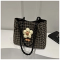 Detail van tweed shopper met lederen touwhandvatten en een grote stoffen bloemhanger - Zwart