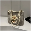 Detail van een geweven strooien draagtas met tweed textuur en bloemenhanger - Wit