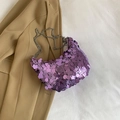 Lila Pailletten-Hobo-Tasche mit Silberkette auf einem modischen beigen Blazer - Lila