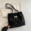 Chic black tote bag with unique crinkled texture and elegant butterfly charm detail - Black
