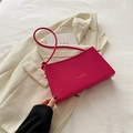 Elegant fuchsia pink leather underarm bag with gold logo on white blazer background - Rose Pink