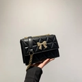 Schwarze Stepptasche mit goldenem Bogenschloss und Kettenschultergurt für Damen - Schwarz