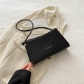 Minimalist black leather underarm bag with gold FASHION lettering on chic blazer - Black