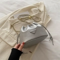 Schicke silberne Beuteltasche mit Kettenriemen und modischer Logo-Plakette im Detail - Silber