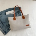 Off-white canvas tote bag with brown leather straps and fashion label in top-down view - Brown