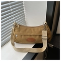 Detalle de bolso de lona caqui con parche de cuero y correa ancha ajustable - Marrón