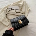 Sac bandoulière plissé noir élégant avec fermoir doré et chaîne sur un blazer blanc - Noir
