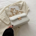 Sac bandoulière blanc avec chaîne dorée sur blazer beige, style chic et élégant - Blanc