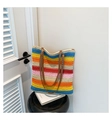 Detailed close-up of rainbow striped woven tote bag with brown synthetic leather straps - Rainbow