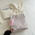 Sac hobo brodé rose avec motifs floraux, glands et un charme en perles blanches - Rose