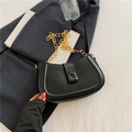 Minimalist black crescent leather bag with chunky gold chain strap on white fabric - Black
