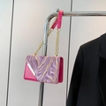 Bolso bandolera magenta con solapa de mármol púrpura y cadena dorada en estudio - Rosa Rojo