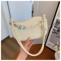Detail of elegant cream handbag featuring pearl chain, silver hearts and knotted handle - Off White