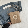 Woven straw crossbody bag featuring a white daisy flower and slim rope shoulder strap - Khaki