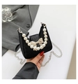 Detail of black glitter crossbody bag featuring a golden bow and pearl handle - Black