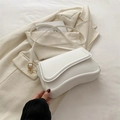 Borsa a tracolla bianca minimalista con fondo curvo e dettagli in metallo dorato - Bianco