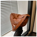 Close-up of brown crescent bag showing litchi texture and white butterfly embroidery - Brown