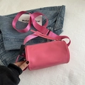 Bolso cilíndrico rosa con correa ancha de tejido y acabado en cuero mate - rosa intenso