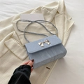 Lichtblauwe crossbodytas met marmeren textuur en zilveren striksluiting en ketting - Blauw
