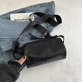 Bolso cilíndrico negro minimalista de cuero mate con correa ancha de tela suave - Negro