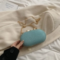 Elegant teal sequin evening bag with gold handle and chain strap on fabric background - Blue