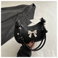 Detalle de bolso media luna negro con lazo plateado y correa con nudos diseño - Negro