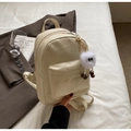 Détail d'un mini sac à dos crème avec texture matelassée et porte-clé peluche - Blanc Cassé