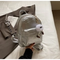 Détail d'un mini sac à dos argenté avec design patchwork et breloque monstre en peluche - Argenté