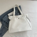 Bolso tote blanco minimalista con cordones laterales sobre fondo de tela neutra - Blanco