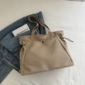 Bolso tote de lona caqui con cordón y cierre magnético sobre ropa de cama blanca - Caqui