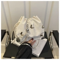 Detail of cream drawstring bucket bag with silver butterfly patches and chain strap - White