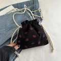 Black corduroy drawstring bucket bag with red strawberry pattern on denim background - Black
