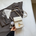 Elegante cremeweiße vertikale Handy-Umhängetasche mit Fashion-Logo und Plüschanhänger - Gebrochenes Weiß