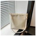 Dettaglio della borsa tote avorio con cuciture geometriche e ombre di luce naturale - Bianco