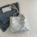 Weiße Eimertasche mit hellblauen Schmetterlingsmustern und dünnen Schultergurten - Schmetterling