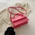 Borsa a tracolla rosa acceso con logo dorato su sfondo di blazer bianco rifinito - rosa acceso