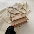 Chic light khaki PU leather crossbody handbag with gold logo on soft fabric background - Khaki