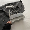 Light grey crossbody bag with silver sequin flap and wavy bottom on suit background - Silver