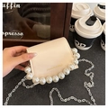 Dettaglio della mini borsa a patta crema con bordo di perle e catena argentata elegante - Bianco Sporco