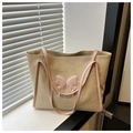 Détail d'un grand sac cabas en paille avec nœud en cuir rose et anses pour la plage - Rose