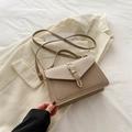Bolso bandolera estructurado de cuero sintético caqui con hebilla dorada sobre traje beige - Caqui