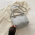 Schicke hellgraue Eimertasche mit Marmormuster und Knotengriffen auf Blazer - Silber