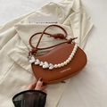 Bolso tipo silla de montar marrón con cadena de perlas y corazones sobre un blazer - Marrón