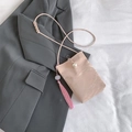 Mini borsa a tracolla rosa con fibbia di perle e nappina su sfondo di giacca grigia - Rosa