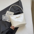 Chic beige bucket bag with ribbon bow detail shown in a minimalist lifestyle setting - White